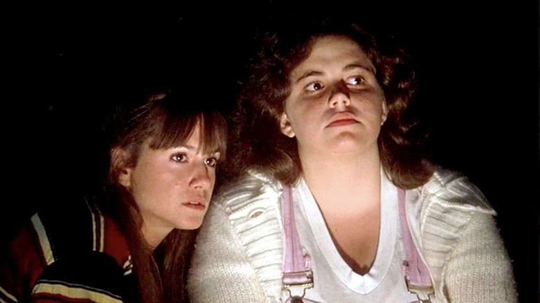 Holly Hunter as Sophie and Ame Segull as Rhoda sitting around a campfire in The Burning
