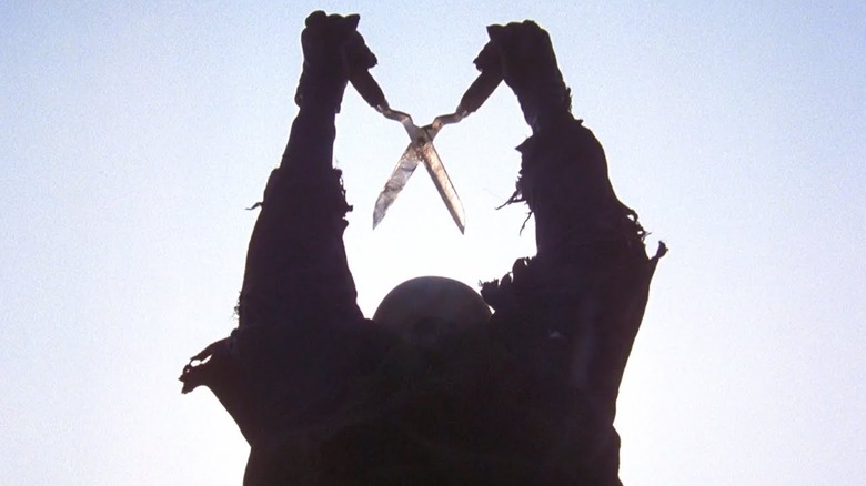 The killer holding up a pair of gardening sheers in The Burning