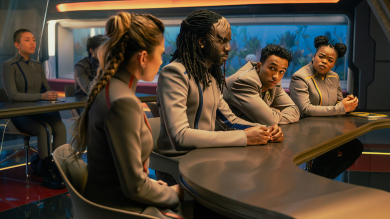 Bella Shepard as Genesis, Karim Diané as Jay-Den, Sandro Rosta as Caleb, and Kerrice Brooks as Sam seated at a desk in class in Star Trek: Starfleet Academy