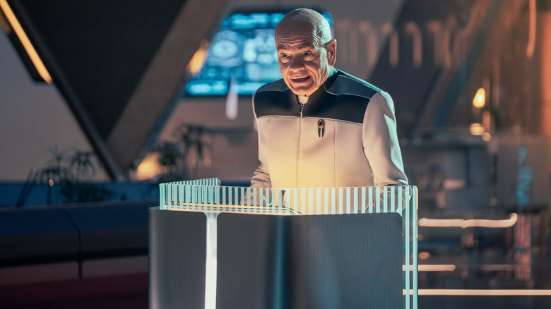 Robert Picardo as The Doctor standing behind a podium on a debate stage in Star Trek: Starfleet Academy