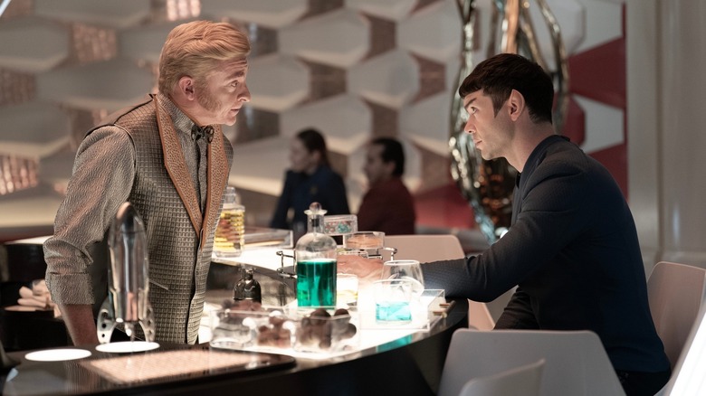 Rhys Darby as Trelane speaking to Ethan Peck as Spock at a bar in Star Trek: Strange New Worlds