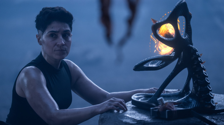 Melissa Navia como Ortegas em Star Trek: Strange New Worlds, parecendo preocupado enquanto trabalhava em um pedaço de maquinaria Gorn