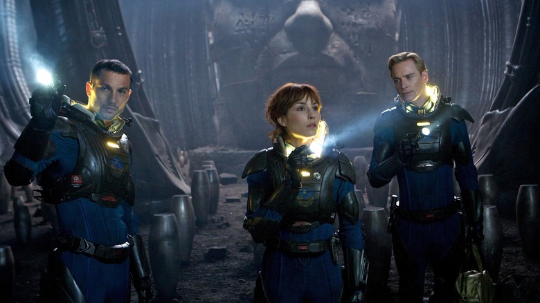 Logan Marshall-Green como Charlie Holloway, Noomi Rapace como Elizabeth Shaw e Michael Fassbender como David explorando uma sala desconhecida cheia de recipientes ovais em Prometheus