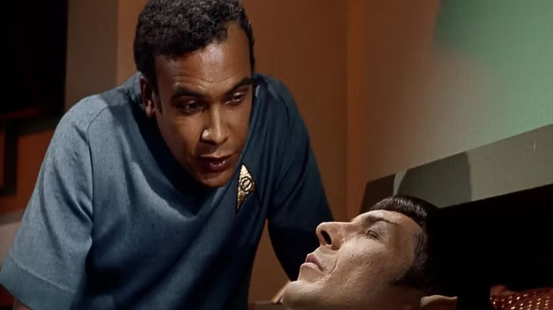 Star Trek: The Original Series - Dr. M'Benga standing over Spock, who is resting