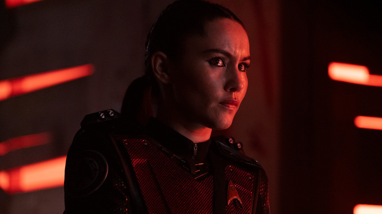 Christina Chong as La'an bathed in red light and looking concerned in Star Trek: Strange New Worlds