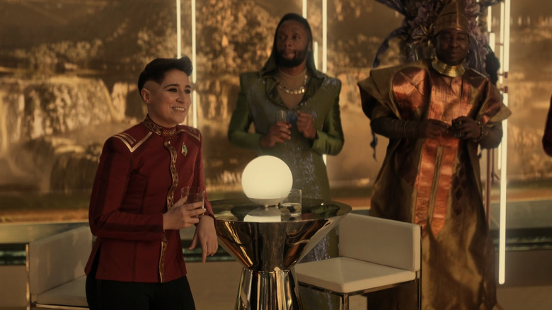 Melissa Navia as Ortegas on Star Trek: Strange New Worlds season 3 episode 2, standing on the sidelines while her friends dance
