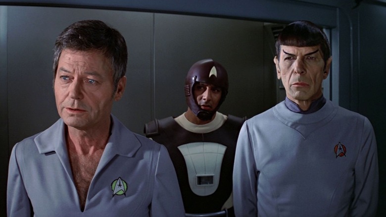 Dr. McCoy, a man in a dippy helmet, and Spock all standing abreast in Star Trek: The Motion Picture