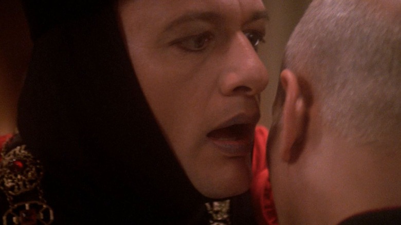Q, about to whisper something into Picard's ear on Star Trek: The Next Generation.