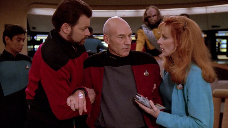 Riker and Dr. Crusher helping Captain Picard off the floor in Star Trek: The Next Generation