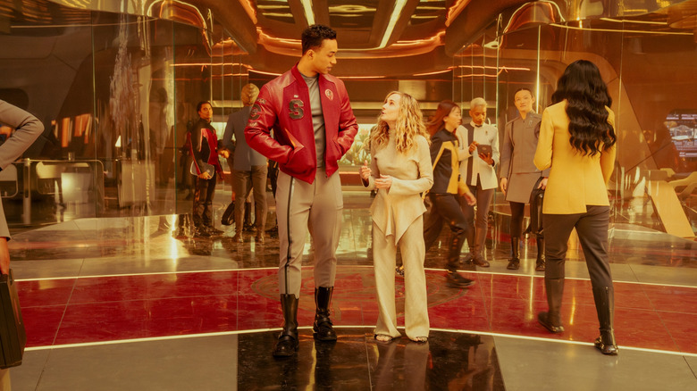 Sandro Rosta as Caleb and Holly Hunter as Captain Nahla Ake walking through an atrium filled with students and teachers in Star Trek: Starfleet Academy