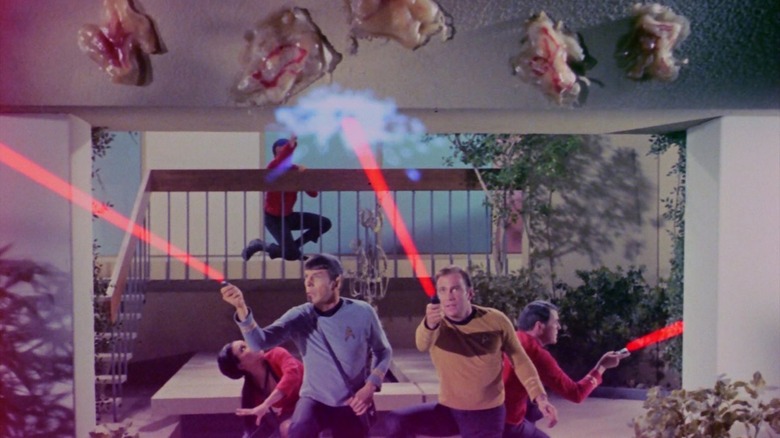 The crew of the Enterprise firing phasers at weird flying amoeba monsters in Star Trek