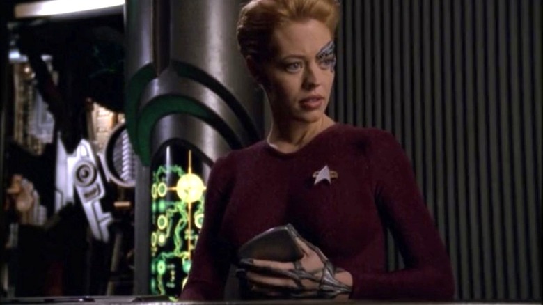 Jeri Ryan as Seven of Nine looks to the right while in a mechanical room on the Voyager in Star Trek: Voyager