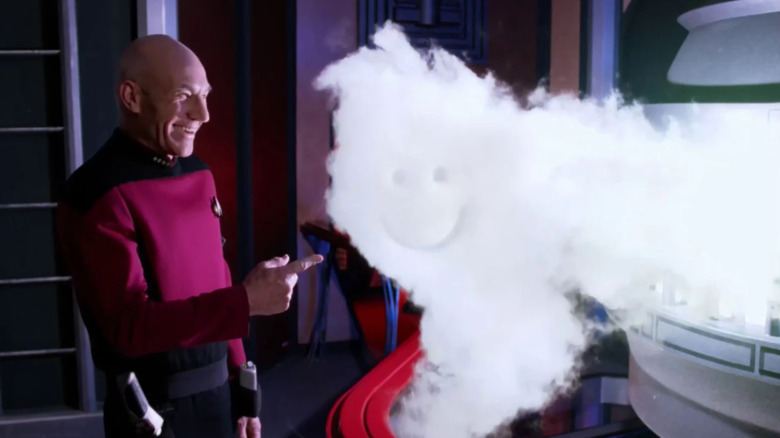 Jean-Luc Picard (Patrick Stewart) laughs at a smiley face drawn into a smoke cloud in Star Trek: The Next Generation