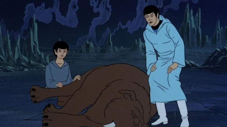 A young Spock (Keith Sutherland) kneels beside a sehlat as an adult Spock (Leonard Nimoy) stands over them in Star Trek: The Animated Series