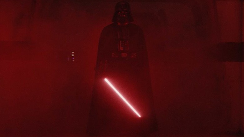 Darth Vader igniting his red lightsaber in the hallway at the end of Rogue One: A Star Wars Story