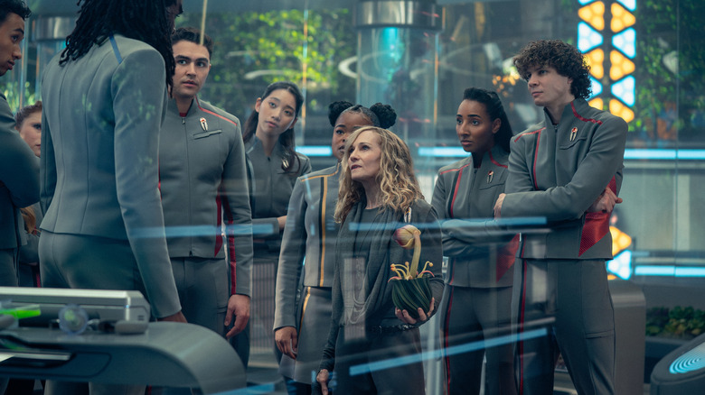 Holly Hunter as Nahla Ake holding a potted plant as Kerrice Brooks as Sam, Karim Diane as Jay-Den, George Hawkins as Darem Reymi, and Sandro Rosta as Caleb Mir look in in Star Trek: Starfleet Academy