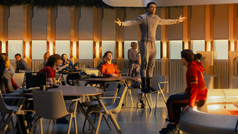 Sandro Rosta as Caleb Mir standing on a chair and delivering an impassioned speech in front of several other students in Star Trek: Starfleet Academy