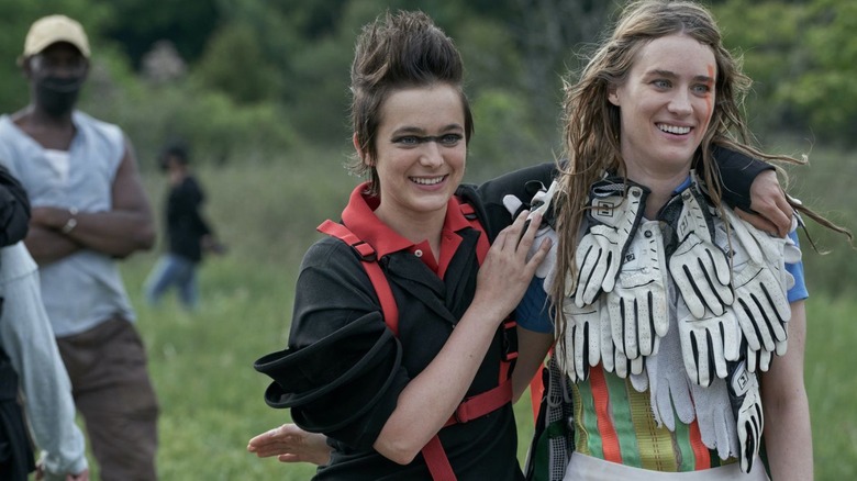 Two performers smile, embrace