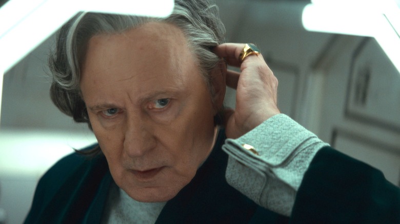 Stellan Skarsgård as Luthen Rael adjusting his wig in front of a mirror in Andor season 2