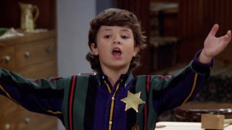 Josh Byrne as Brendan Lambert, raising his arms while wearing a sheriff's star on Step by Step