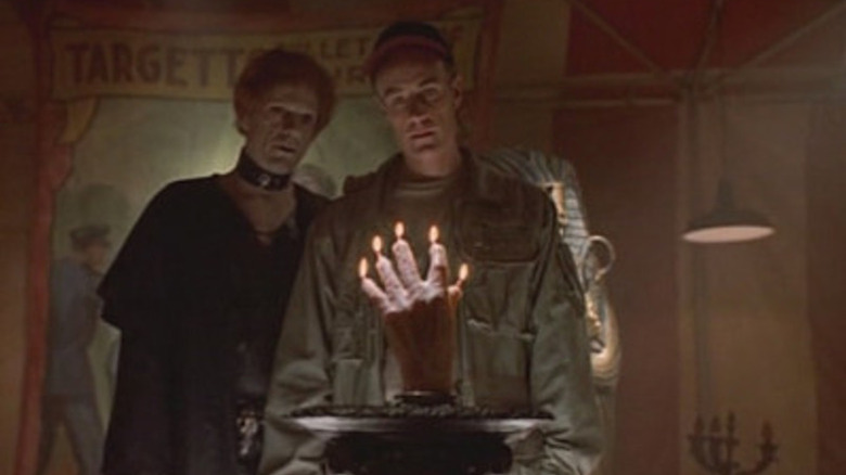 ఆరోన్ క్విక్‌సిల్వర్ క్విక్‌సిల్వర్ హైవేలో ప్రయాణికుడికి చేతి ఆకారంలో ఉన్న కొవ్వొత్తిని చూపుతోంది