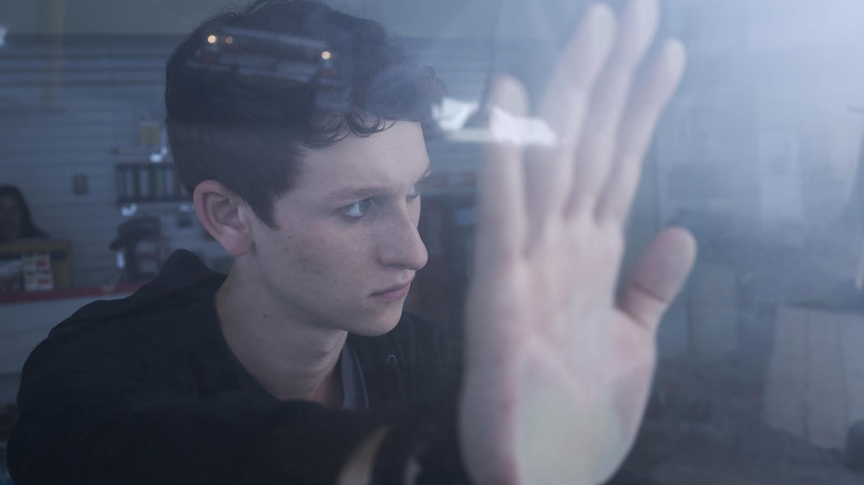 Russell Posner as Adrian Garff holding his hand against a window in The Mist