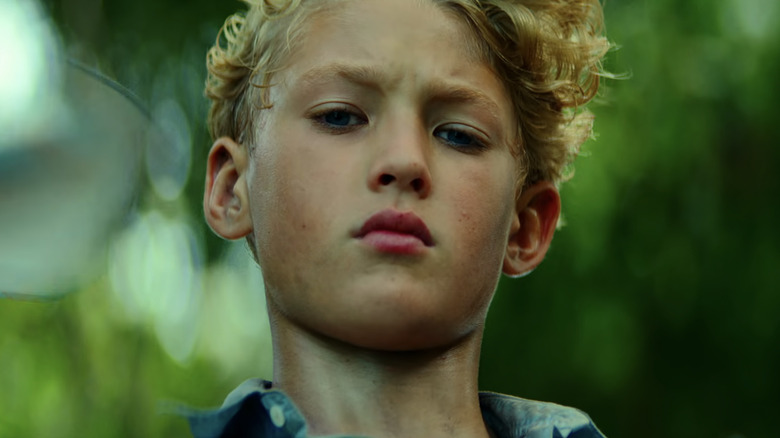 Lox Pratt's Jack is seen in closeup as he stands ina. forest in Lord of the Flies