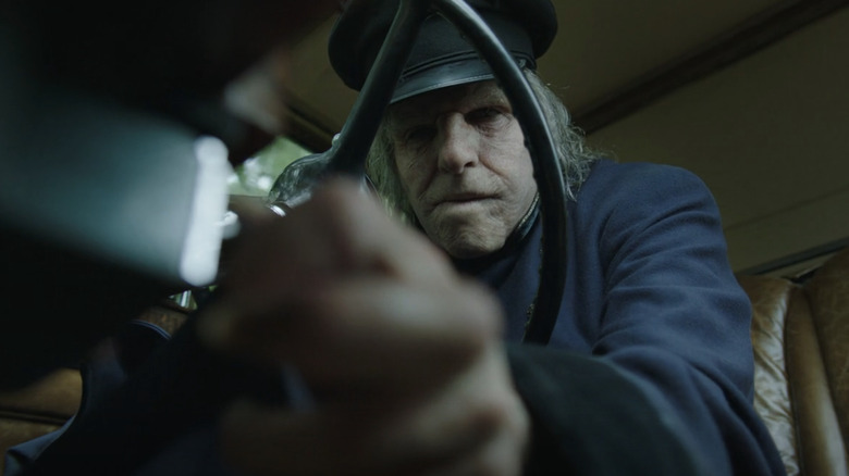 Zachary Quinto's Charlie Manx sits behind the wheel of a car in NOS4A2