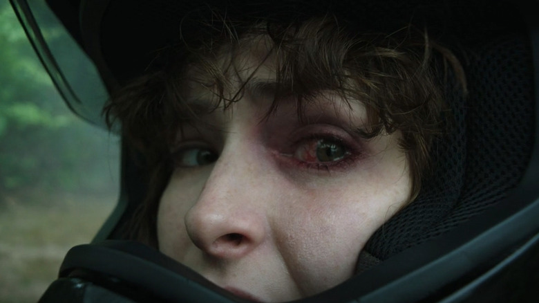 Ashleigh Cummings' Victoria McQueen looks back with a red eye while wearing a motorcylce helmet in NOS4A2