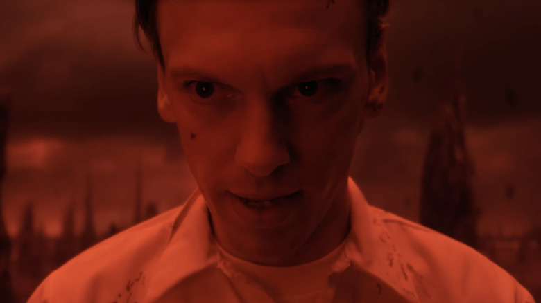 Jamie Campbell Bower's Henry Creel is seen in closeup lit by red light in Stranger Things