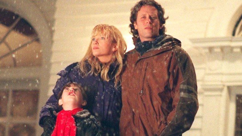 Jack, Wendy, and Danny stand in the show in front of the Overlook in Stephen King's The Shining