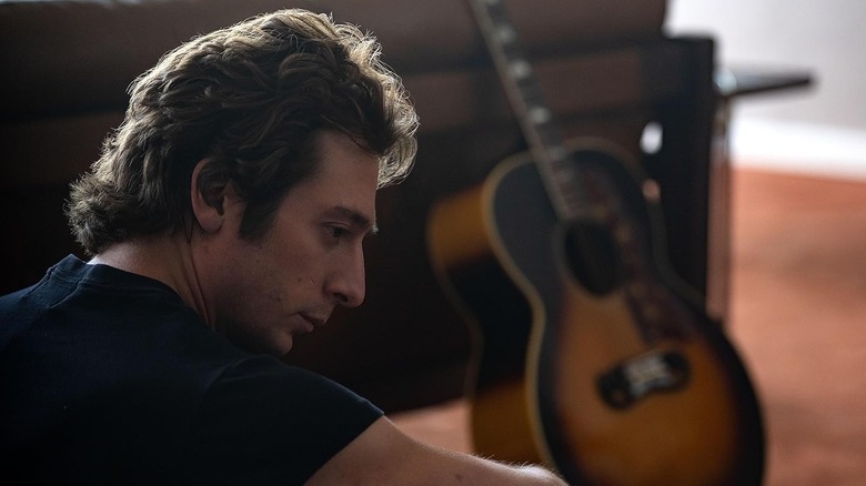 Jeremy Allen-White as Bruce Springsteen sits next to a guitar in Deliver Me from Nowhere
