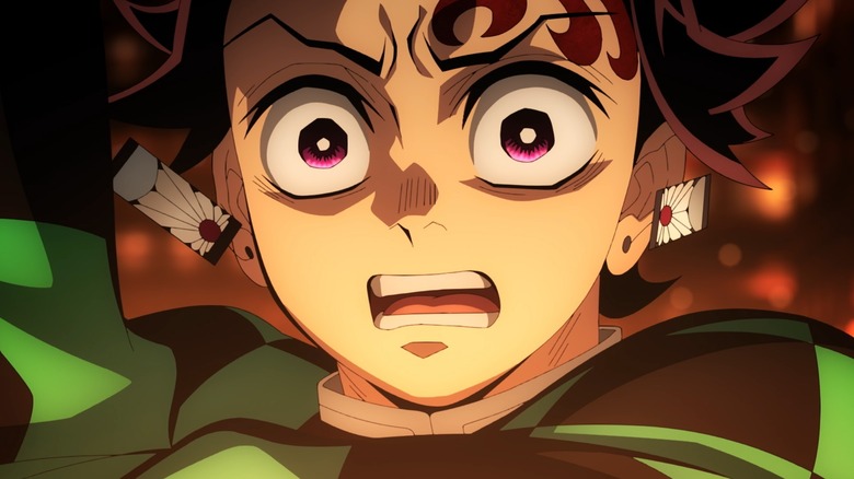 Tanjiro Kamado com os olhos arregalados em surpresa no Slayer Demon: Kimetsu no Castelo de Yaiba Infinity