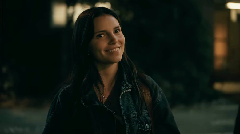 Nikki smiling outside at night in Obsession