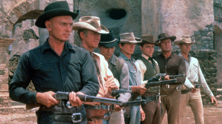 The Magnificent Seven circa 1960 are lined up with rifles