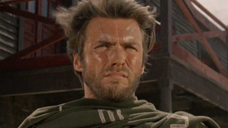 పేరు లేని క్లింట్ ఈస్ట్‌వుడ్ యొక్క మనిషి ఒక పిడికెడు డాలర్లలో దూరం వైపు చూస్తున్నాడు