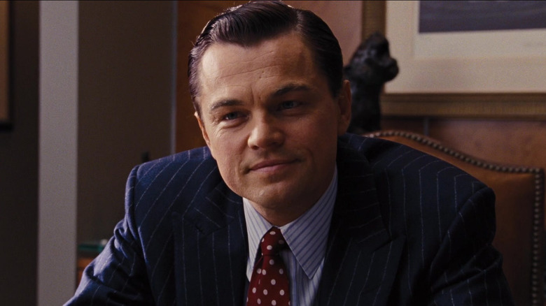 Leonardo DiCaprio as Jordan Belfort smiling wryly in The Wolf of Wall Street