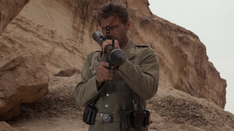 Harrison Ford in the role of Indiana Jones carrying a missile launcher in Rids of the Lock