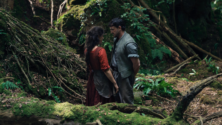 Jessie Buckley as Agnes Hathaway and Paul Mescal as William Shakespeare staring into each other's eyes in a forest in Hamnet