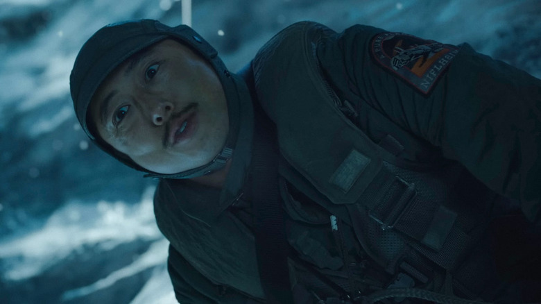 Timo (Steven Yeun) looks down in a tundra in Mickey 17