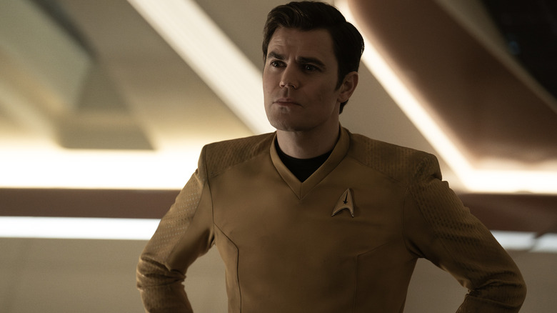 Paul Wesley in the role of James T Kirk stands with his hands on the hips in new strange worlds