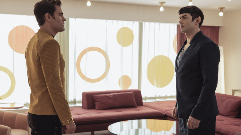 Paul Wesley as James T. Kirk and Ethan Peck as Spock standing in a living room facing each other in Star Trek: Strange New Worlds