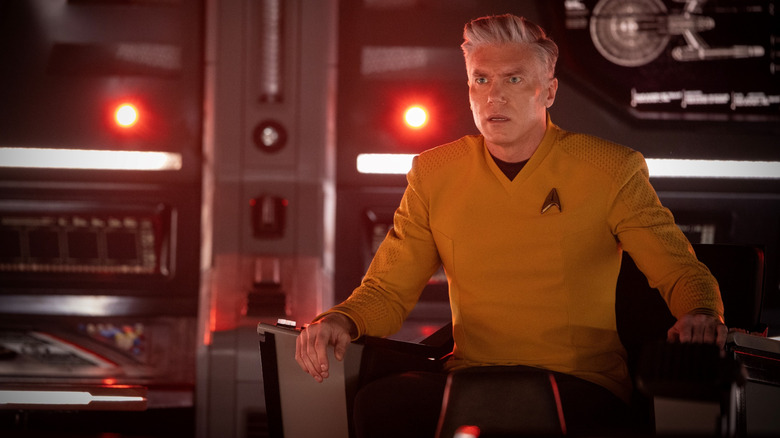 Anson Mount as Christopher Pike sitting in the captain's chair of a starship looking alarmed in Star Trek: Strange New Worlds