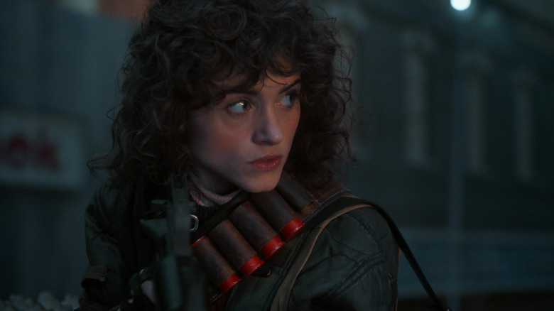 Nancy Wheeler (Natalia Dyer) glances to her left while carrying ammo in Stranger Things