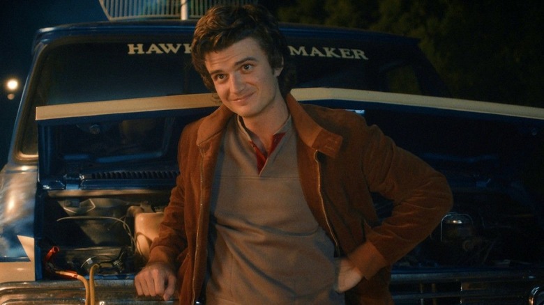 Steve Harrington (Joe Keery) smiles while standing by a van in Stranger Things