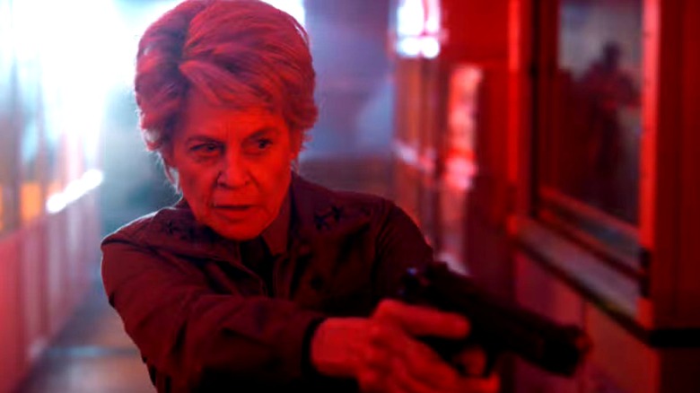 Dr. Kay pointing a gun in a red hallway on Stranger Things