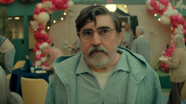 Sam (Alfred Molina) standing in front of a group of senior citizens on 