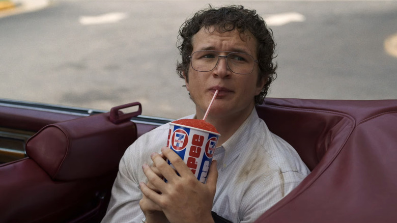 Alec Utgoff's Dr. Alexei sips a slurpee while sitting in a car in Stranger Things