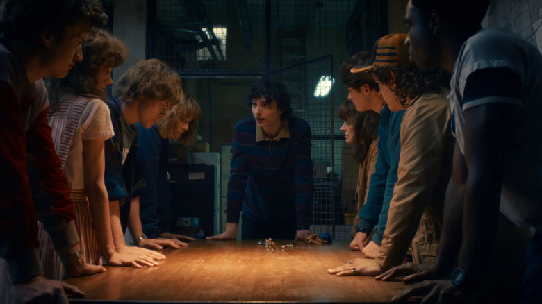Mike Wheeler and his friends and family gathered around a table in Stranger Things