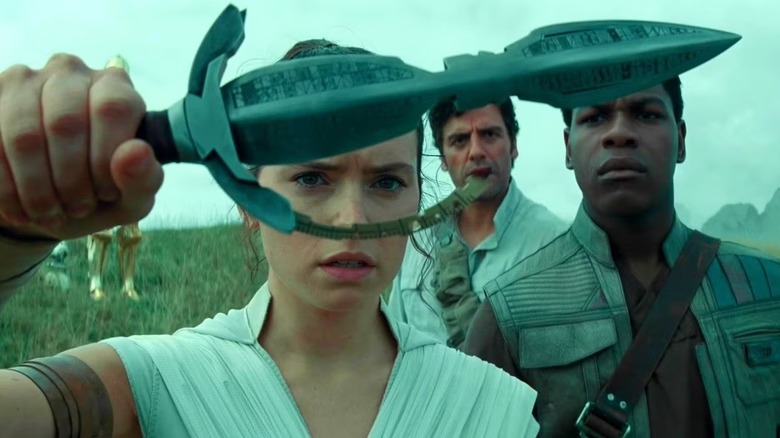 Rey, Finn, and Poe looking at a Sith dagger in "Star Wars: The Rise of Skywalker"